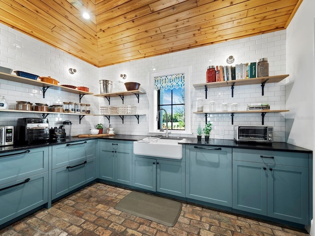 kitchen with blue cabinetry, tasteful backsplash, wooden ceiling, and sink