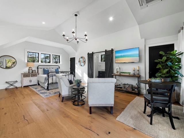 living room featuring light wood-type flooring, a barn door, vaulted ceiling, and a notable chandelier