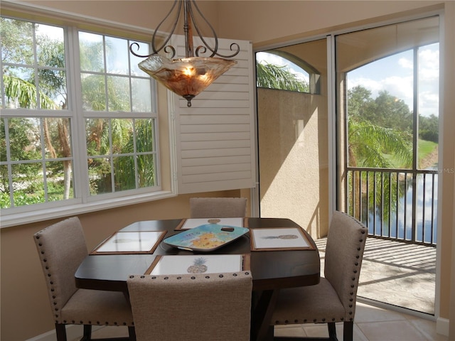 tiled dining room featuring a water view