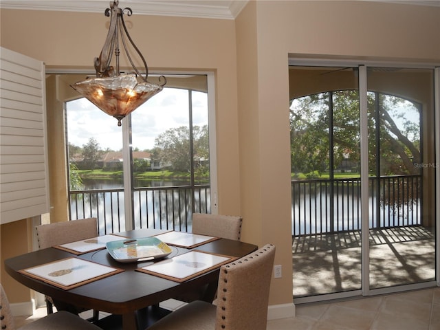 dining room with a chandelier, a water view, light tile patterned floors, and ornamental molding