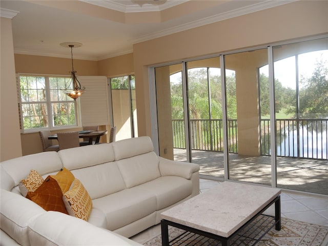 tiled living room featuring a water view, a notable chandelier, and ornamental molding