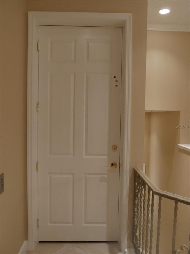 doorway to outside featuring light tile patterned flooring and crown molding