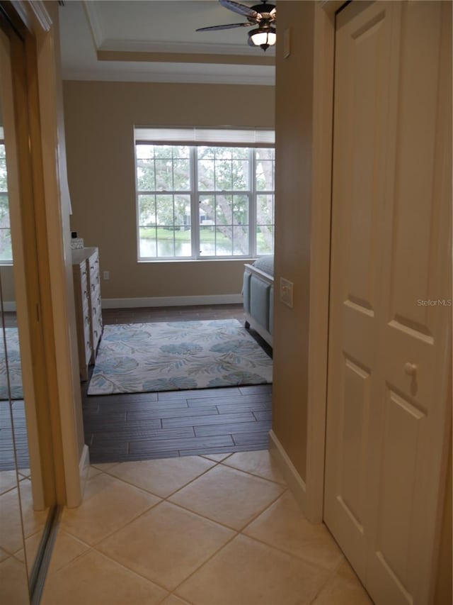 corridor with light tile patterned flooring and crown molding