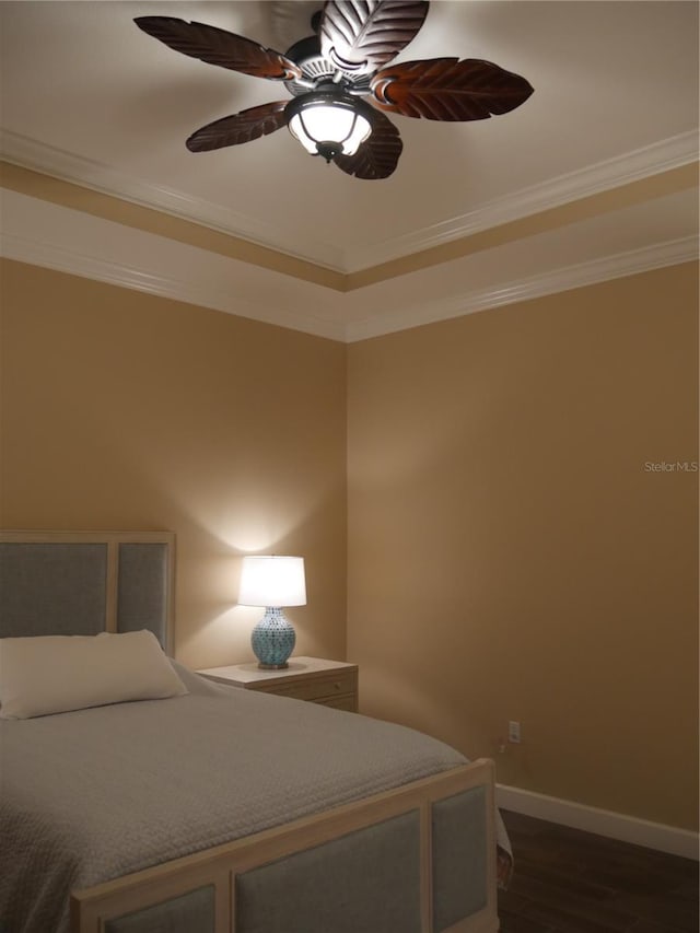 bedroom with ornamental molding, dark wood-type flooring, and ceiling fan