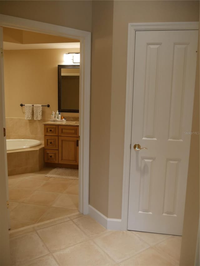 bathroom featuring vanity, tiled bath, and tile patterned floors