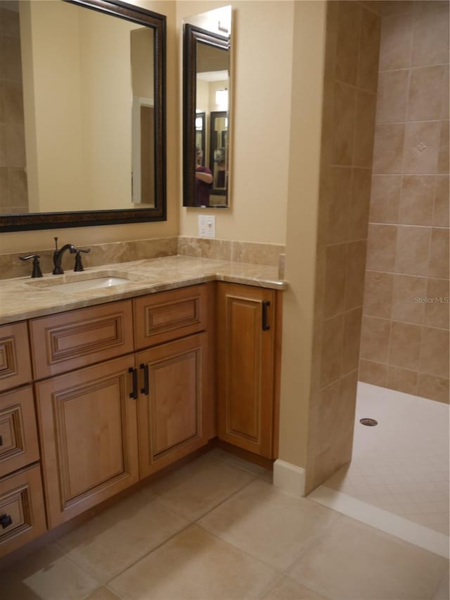 bathroom featuring tiled shower, vanity, and tile patterned floors