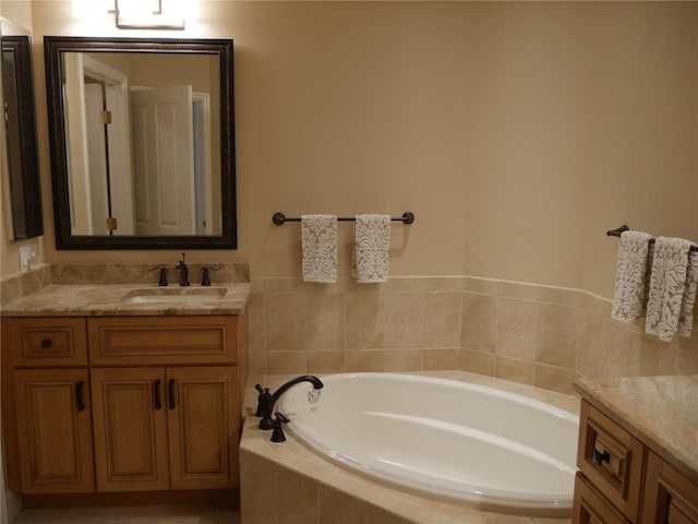 bathroom with tiled bath and vanity