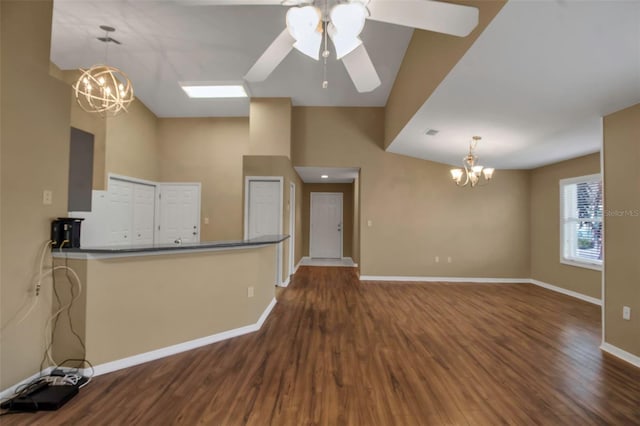 interior space featuring ceiling fan with notable chandelier, wood-type flooring, and vaulted ceiling