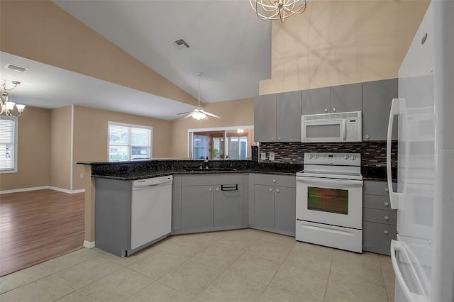 kitchen with backsplash, gray cabinets, white appliances, and sink