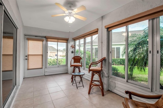 sunroom / solarium featuring a wealth of natural light and ceiling fan