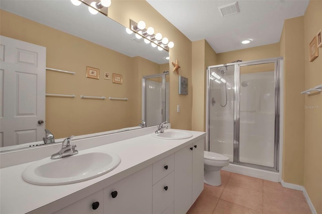 bathroom with tile patterned flooring, vanity, toilet, and a shower with shower door