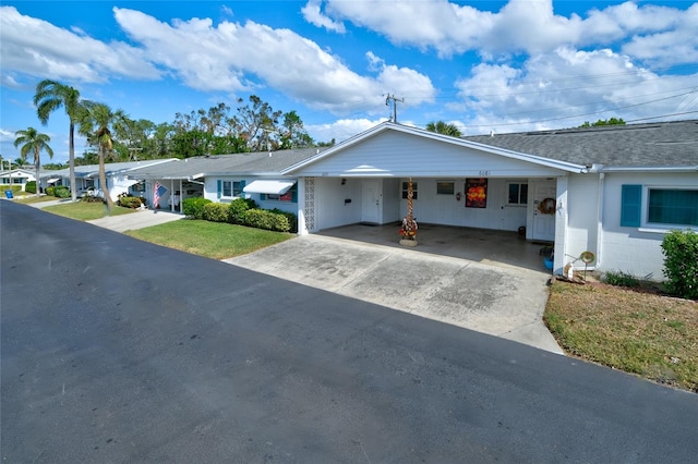 ranch-style house featuring a front yard and a carport