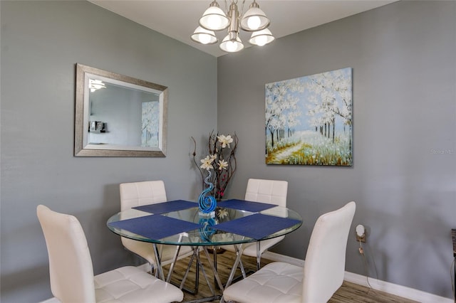 dining area with hardwood / wood-style flooring and a chandelier