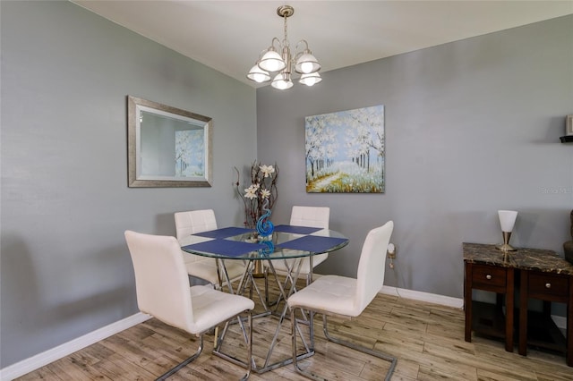 dining space with a chandelier and light hardwood / wood-style flooring