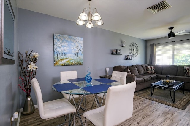 dining room featuring light hardwood / wood-style floors and ceiling fan with notable chandelier