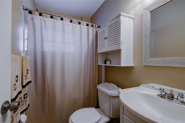 bathroom featuring toilet, vanity, and curtained shower