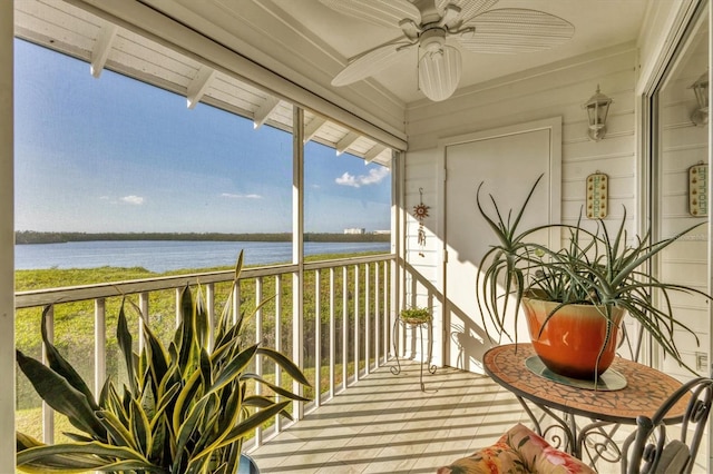 balcony with ceiling fan and a water view