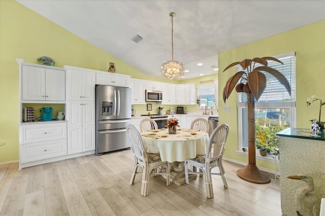 dining room featuring vaulted ceiling and an inviting chandelier