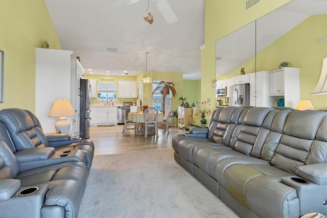 carpeted living room featuring ceiling fan and sink