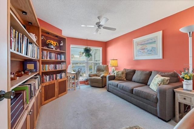 interior space with a textured ceiling, ceiling fan, and light colored carpet