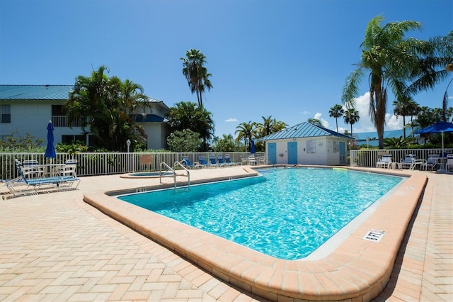 view of swimming pool featuring a patio area and a hot tub