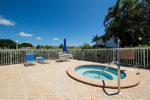 view of pool with a hot tub and a patio