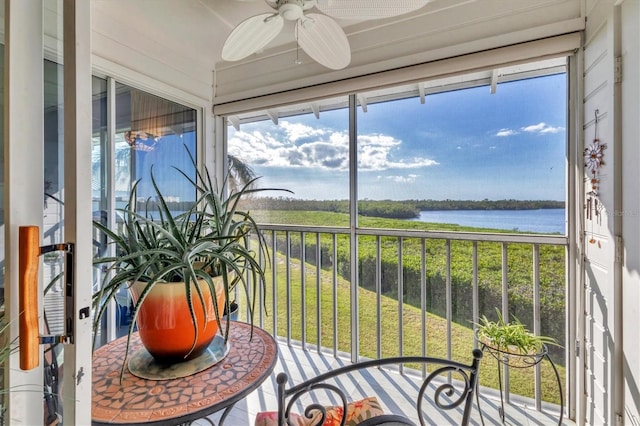 sunroom / solarium featuring a water view, ceiling fan, and a wealth of natural light