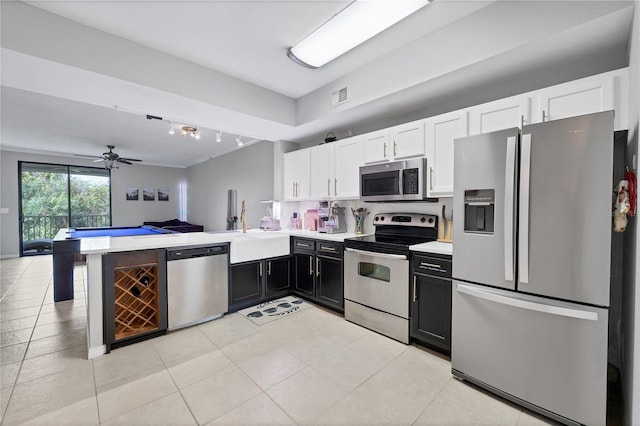 kitchen with kitchen peninsula, ceiling fan, white cabinetry, and appliances with stainless steel finishes