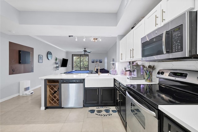 kitchen featuring kitchen peninsula, sink, crown molding, and stainless steel appliances