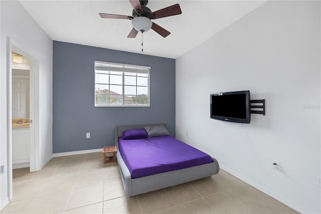 bedroom with ensuite bathroom, ceiling fan, and light tile patterned floors