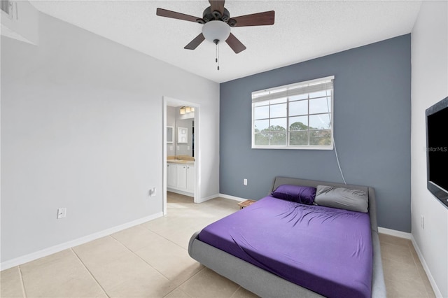 tiled bedroom featuring ensuite bathroom, a textured ceiling, and ceiling fan