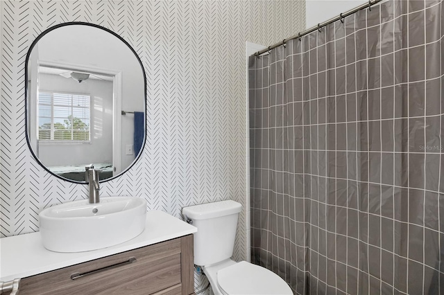 bathroom with curtained shower, vanity, and toilet