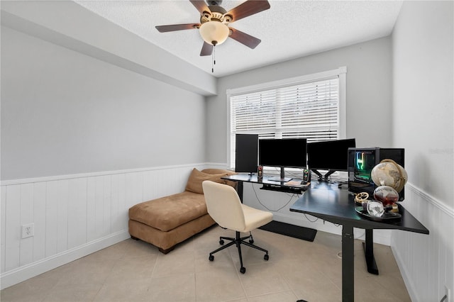 tiled office space featuring a textured ceiling and ceiling fan