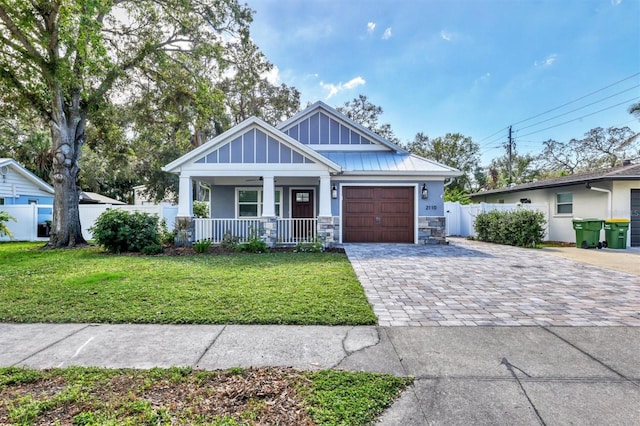 view of front of house with a front lawn, a porch, and a garage