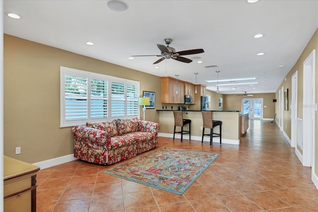 living room with light tile patterned floors and ceiling fan