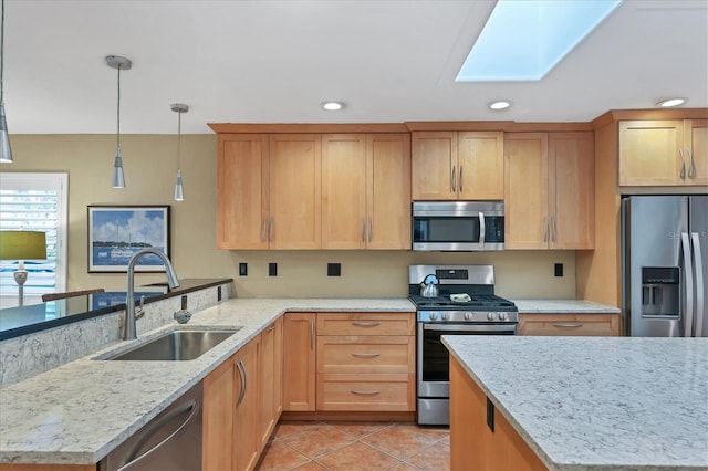 kitchen featuring sink, light tile patterned flooring, hanging light fixtures, appliances with stainless steel finishes, and light stone counters