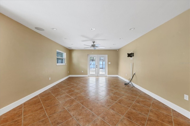 tiled empty room featuring ceiling fan and french doors