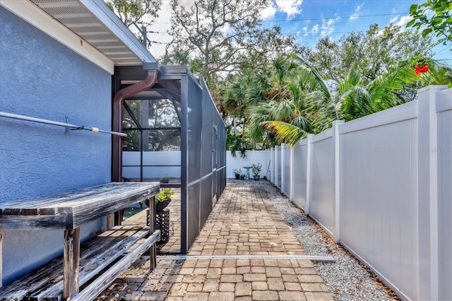 view of patio featuring glass enclosure