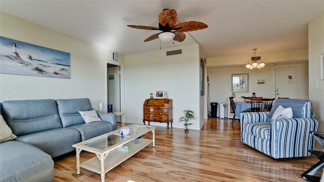 living room featuring hardwood / wood-style floors and ceiling fan with notable chandelier