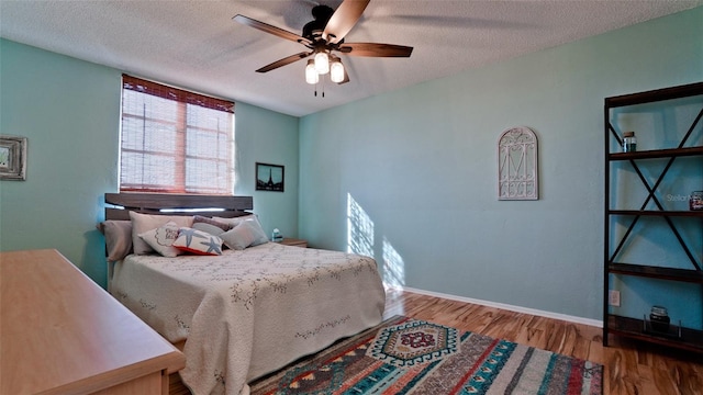 bedroom featuring hardwood / wood-style flooring, ceiling fan, and a textured ceiling