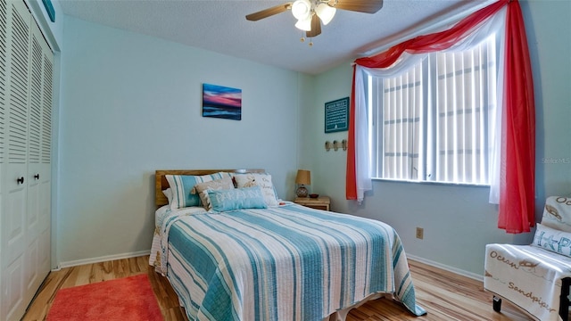 bedroom featuring light hardwood / wood-style floors, ceiling fan, a textured ceiling, and a closet