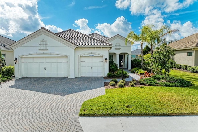 mediterranean / spanish-style house featuring a front lawn and a garage