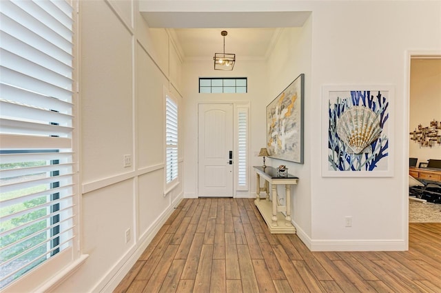 entrance foyer with light wood-type flooring and crown molding