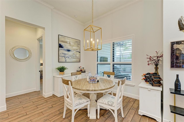 dining area featuring light wood-type flooring, an inviting chandelier, and ornamental molding