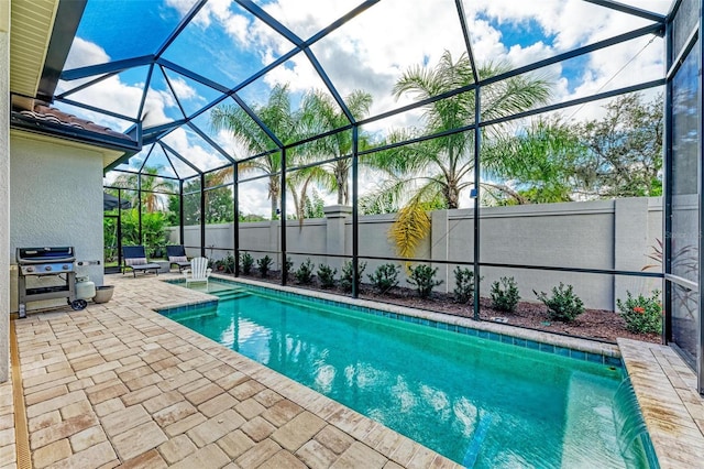 view of pool with a lanai, a grill, and a patio