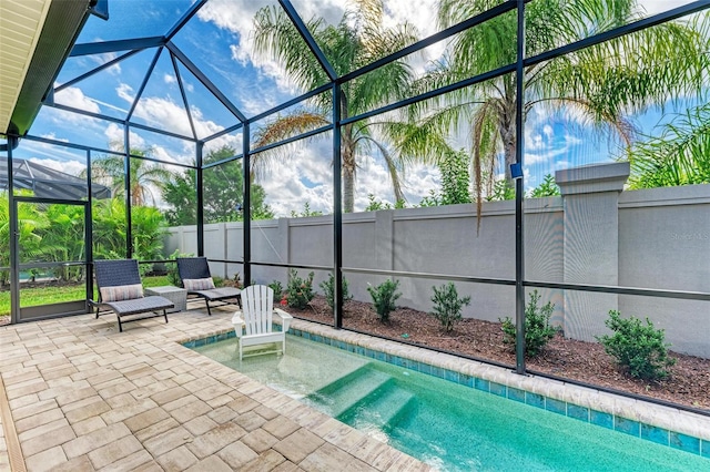 view of swimming pool featuring a hot tub, a patio area, and a lanai