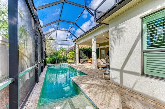 view of pool with outdoor lounge area, a lanai, ceiling fan, and a patio area