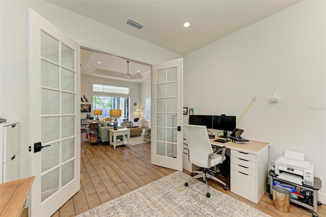 office area with a raised ceiling, french doors, and light hardwood / wood-style flooring