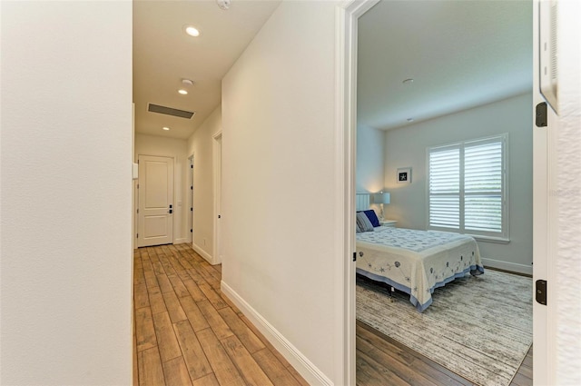 corridor with hardwood / wood-style flooring