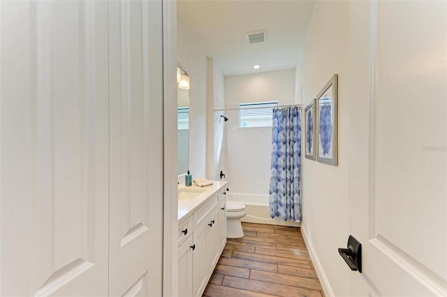 full bathroom with vanity, hardwood / wood-style floors, toilet, and shower / tub combo